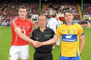 22 May 2011; Team captains Graham Canty, Cork, and Gordon Kelly, Clare, right, shake hands in front of referee Eddie Kinsella before the game. Munster GAA Football Senior Championship Quarter-Final, Cork v Clare, Pairc Ui Chaoimh, Cork. Picture credit: Pat Murphy / SPORTSFILE