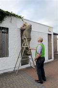 4 June 2011; Westmeath County Board Chairman, Tom Farrell, uses a brick to hammer home a nail on a sign outside a turnstile while Chief Steward Seamus Conrol holds the ladder. Leinster GAA Hurling Senior Championship Quarter-Final, Westmeath v Galway, Cusack Park, Mullingar, Co. Westmeath. Picture credit: Ray McManus / SPORTSFILE