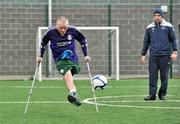 18 June 2010; Damien Hegarty, from Artane, Dublin, takes a shot watched by Denis Hyland, Development Officer at the Football Association of Ireland, during Ireland's first amputee football club training session. Mountview Communinty Sports Centre, Clonsilla, Co. Dublin. Picture credit: Brendan Moran / SPORTSFILE