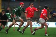 25 February 2002; Derek Barrett of Cork handpasses to team-mate Pat Ryan, despite the attentions of Ollie Moran of Limerick during the Allianz National Hurling League Division 1B Round 1 match between Limerick and Cork at the Gaelic Grounds in Limerick. Photo by Brendan Moran/Sportsfile