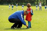 7 July 2011; Former Dublin football manager Paul Caffrey ties the laces on Cillian Gavin's shoes during a GAA VHI Cúl Camp in Clonliffe College, Dublin. The camps, sponsored and subsidised by Croke Park and the GAA, catered for more than 150 local children from the Croke Park locality under the direction of camp co-ordinator Liam Ryan this week. Clonliffe College, Clonliffe Road, Dublin. Picture credit: Brendan Moran / SPORTSFILE