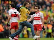 17 July 2011; A celebrating Donegal supporter runs past Derry players Kevin McGuckin, 3, and Dermot McBride, at the final whistle. Ulster GAA Football Senior Championship Final, Derry v Donegal, St Tiernach's Park, Clones, Co. Monaghan. Picture credit: Brendan Moran / SPORTSFILE