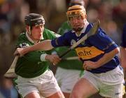 10 March 2002; Eamon Corcoran of Tipperary clears under pressure from Limerick's Mark Keane during the Allianz National Hurling League Division 1B Round 2 match between Tipperary and Limerick at Semple Stadium in Thurles, Tipperary. Photo by Ray McManus/Sportsfile