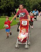 31 July 2011; Paul Byrne, from Saggart, Co. Dublin, runs to the finish with 15 month Eve and five year old Cillian, during Athletics Ireland Family Fitness Festival at Farmleigh. Phoenix Park, Dublin. Picture credit: Ray McManus / SPORTSFILE