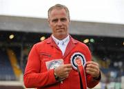 6 August 2011; Rene Tebbel, Germany, holds up his rosette after winning the Land Rover Puissance. Dublin Horse Show 2011. RDS, Ballsbridge, Dublin. Picture credit: Barry Cregg / SPORTSFILE