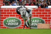 6 August 2011; Dave Quigley, Ireland, competing on Valetto Jx, is thrown from his mount after failing to clear the &quot;Wall&quot; in the jump off during the Land Rover Puissance. Dublin Horse Show 2011. RDS, Ballsbridge, Dublin. Picture credit: Barry Cregg / SPORTSFILE