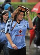 6 August 2011; A Dublin supporter uses her bag to shelter from the rain on her way to the GAA Football All-Ireland Senior Championship Quarter-Final, Dublin v Tyrone, Croke Park, Dublin. Picture credit: Daire Brennan / SPORTSFILE