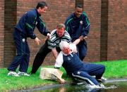 25 March 2002; Mick Byrne is rescued by Republic of Ireland players Gary Kelly, left, Clinton Morrison and Head of Security Tony Hickey after he slipped into the water ahead of a Republic of Ireland squad training session at John Hyland Park in Baldonnel, Dublin. Photo by David Maher/Sportsfile