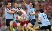 6 August 2011; Dublin players, left to right, Ger Brennan, Michael Darragh Macauley, Denis Bastick and Cian O'Sullivan combine to tackle Tyrone's Kevin Hughes. GAA Football All-Ireland Senior Championship Quarter-Final, Dublin v Tyrone, Croke Park, Dublin. Picture credit: Ray McManus / SPORTSFILE