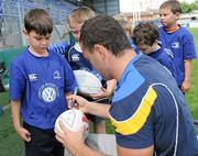 17 August 2011; George Reilly, age 7, from Dublin, has his rugby ball signed by Leinster's David Kearney during a Volkswagen Leinster Rugby Summer Camp Donnybrook pro visit. Donnybrook Stadium, Donnybrook, Dublin. Picture credit: Barry Cregg / SPORTSFILE