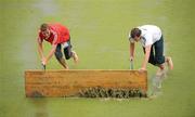 22 August 2011; Volunteers clear rain water from the pitch after the game. GANT EuroHockey Nations Men's Championships 2011, Group B, Ireland v France. Warsteiner HockeyPark, Mönchengladbach, Germany. Picture credit: Diarmuid Greene / SPORTSFILE