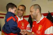 5 April 2002; Four year Evan Osam is introduced by his dad Paul to former Republic of Ireland International Paul McGrath in the dressing room before the start of the game Paul Osam Testimonial Match between St Patrick's Athletic and Shamrock Rovers at Richmond Park in Dublin. Photo by David Maher/Sportsfile