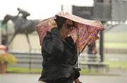 10 September 2011; A punter takes cover from the showers during the day. The Curragh Racecourse, The Curragh, Co. Kildare. Photo by Sportsfile