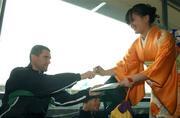 17 May 2002; Republic of Ireland captain Roy Keane signs an autograph for Satomi Bekki, in traditional kimono dress, a member of The Ireland Japan Association, at Dublin Airport prior to the team's departure to their base on Saipan island in preparation tor the World Cup 2002 in Japan and Korea. Soccer. Picture credit; David Maher / SPORTSFILE *EDI*