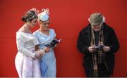 25 April 2017; Racegoers Niamh Lawler, left, from Moone, Co Kildare, and Katie Ann Ging, from Crookstown, Co Kildare, study the form with Sean Maher, from Templemore, Co Tipperary, who has attended the Punchestown Festival for more than 60 years, at Punchestown Racecourse in Naas, Co Kildare. Photo by Cody Glenn/Sportsfile