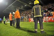28 October 2011; Members of of the fire brigade and security personal stand in front of the Shamrock Rovers supporters after fireworks were thrown on the pitch during the game. Airtricity League Premier Division, Shamrock Rovers v Galway United, Tallaght Stadium, Tallaght, Co. Dublin. Picture credit: David Maher / SPORTSFILE