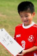 21 May 2002; 5 year old Kenji Sato from Saipan views the autographs he received from members of the Republic of Ireland squad following a Republic of Ireland squad training session at Ada Gym in Susupe, Saipan, Northern Mariana Islands. Photo by David Maher/Sportsfile