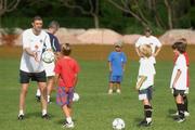 21 May 2002; Niall Quinn teaches some local children some soccer skills following a Republic of Ireland squad training session at Ada Gym in Susupe, Saipan, Northern Mariana Islands. Photo by David Maher/Sportsfile