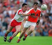 26 May 2002; Tyrone's Ryan McMenamin in action against Ronan Clarke of Armagh during the Bank of Ireland Ulster Senior Football Championship Quarter-Final Replay match between Armagh and Tyrone at St Tiernach's Park in Clones, Monaghan. Photo by Aoife Rice/Sportsfile