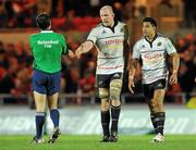 10 December 2011; Munster's Paul O'Connell, alongside team-mate Lifeimi Mafi, exchanges a handshake with referee Romain Poite after victory over Scarlets. Heineken Cup, Pool 1, Round 3, Scarlets v Munster, Parc Y Scarlets, Llanelli, Wales. Picture credit: Diarmuid Greene / SPORTSFILE