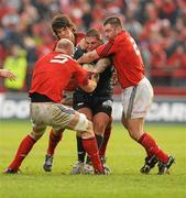 18 December 2011; Rhys Thomas, Scarlets, is tackled by Paul O'Connell, left, Donncha O'Callaghan and Damien Varley, right, Munster. Heineken Cup, Pool 1, Round 4, Munster v Scarlets, Thomond Park, Limerick. Picture credit: Diarmuid Greene / SPORTSFILE