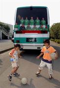 2 June 2002; Two local school children have a kick about next to the Republic of Ireland team coach, which displays only ten players following the removal of Roy Keane, prior to a Republic of Ireland training session in Chiba, Japan. Photo by David Maher/Sportsfile