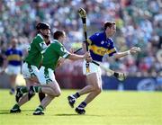 2 June 2002; Brian O'Meara of Tipperary handpasses to a team-mate despite the attentions of Brian Geary, left, and Mark Foley of Limerick during the Guinness Munster Senior Hurling Championship Semi-Final match between Tipperary and Limerick at Páirc Uí Chaoimh in Cork. Photo by Brendan Moran/Sportsfile