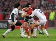 14 January 2012; Lifeimi Mafi, Munster, is tackled by Pierre-Gilles Lakafia, left, Pierre Bernard and Pierre-Manuel Garcia, right, Castres Olympique. Heineken Cup, Pool 1, Round 5, Munster v Castres Olympique, Thomond Park, Limerick. Picture credit: Diarmuid Greene / SPORTSFILE