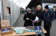 15 January 2012; Mary Donnelly, from Newbridge, Co. Kildare, shows the Kidare annual and calender to supporters Christy Horan, Sarsfields GAA club, and Tom O'Riordan, Moorefield GAA club, before the game. Bord na Mona O'Byrne Cup, Quarter-Final, Kildare v Offaly, St Conleth's Park, Newbridge, Co. Kildare. Picture credit: Dáire Brennan / SPORTSFILE