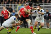 21 January 2012; Setphen Ferris, Ulster, is tackled by Lionel Faure and Clement Ric, right, Clermont Auvergne. Heineken Cup, Pool 4, Round 6, Clermont Auvergne v Ulster, Stade Marcel Michelin, Clermont-Ferrand, France. Picture credit: Oliver McVeigh / SPORTSFILE