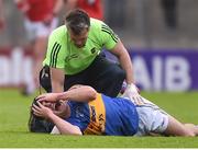 10 June 2017; Michael Quinlivan of Tipperary lies injured on the pitch as he is treated by team physio Ian Dowling before leaving the field injured during the Munster GAA Football Senior Championship Semi-Final match between Cork and Tipperary at Pairc Ui Rinn in Cork. Photo by Matt Browne/Sportsfile