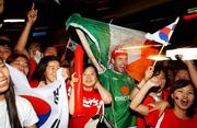 14 June 2002; Republic of Ireland supporter Keith Power celebrates with South Korea supporters following their side's qualification for the FIFA World Cup 2002 Round of 16, after victory over Portugal in their Group D match. Photo by David Maher/Sportsfile