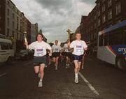 19 June 2002; Members of An Garda S’ochána and the Police Service of Northern Ireland carry the torch en route to the 2002 Special Olympics Ireland National Games Opening Ceremony at Parnell Park in Dublin. Photo by Aoife Rice/Sportsfile