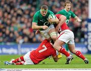 5 February 2012; Jamie Heaslip, Ireland, is tackled by Sam Warburton, left, and Huw Bennett, Wales. RBS Six Nations Rugby Championship, Ireland v Wales, Aviva Stadium, Lansdowne Road, Dublin. Picture credit: Brian Lawless / SPORTSFILE