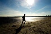 26 February 2012; A jogger runs along Sandymount strand in the Sunday morning sun. Sandymount Strand,  Sandymount, Dublin. Picture credit: Ray McManus / SPORTSFILE