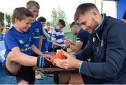 5 July 2017; Rob Kearney and Ross Byrne of Leinster Rugby came out to the Bank of Ireland Leinster Rugby Summer Camp at Donnybrook Stadium. Pictured is Ross Byrne signing the boots of Jack Clarke, age 8, at Donnybrook Stadium in Dublin. Photo by Cody Glenn/Sportsfile