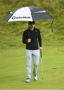 6 July 2017; Rory McIlroy of Northern Ireland shelters from heavy rain on the 3rd green during Day 1 of the Dubai Duty Free Irish Open Golf Championship at Portstewart Golf Club in Portstewart, Co Derry. Photo by Brendan Moran/Sportsfile