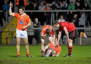 24 March 2012; Peter Carragher, Armagh, is comforted by team-mate Andy Mallon and Down's Eoin McCartan after receiving an injury, as Brendan Donaghy, Armagh, calls for assistance. Allianz Football League, Division 1, Round 6, Armagh v Down, Morgan Athletic Grounds, Armagh. Photo by Sportsfile