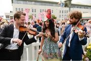 3 August 2017; Louise Mulcahy, from Abbeyfeale, Co Limerick, is serenaded by Vladimir, left, and Anton Jablokov, from Slovakia, in attendance for Ladies' Day during the Galway Races Summer Festival 2017 at Ballybrit, in Galway. Photo by Cody Glenn/Sportsfile