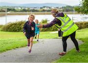 20 August 2017; Parkrun Ireland, in partnership with Vhi, expanded their range of junior events to ten with the introduction of the Oranmore Junior Parkrun on Sunday morning. Junior parkruns are 2km long and cater for 4 to 14 year olds, free of charge providing a fun and safe environment for children to enjoy exercise. To register for a parkrun near you visit www.parkrun.ie. New registrants should select their chosen event as their home location. You will then receive a personal barcode which acts as your free entry to any parkrun event worldwide. Pictured during the Oranmore Junior Parkrun, in partnership with Vhi is Amy McNally, aged 6, from Oranmore, with volunteer Bernie Rogers. Rinville Park, Oranmore, Co Galway. Photo by Diarmuid Greene/Sportsfile