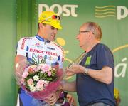 25 May 2012; Adam Armstrong, Dublin Eurocycles, is presented with his Cuchulainn Crystal best place county rider award by Rás legend Gabriel Howard following the sixth stage of the 2012 An Post Rás. Buncrana - Killybegs. Picture credit: Stephen McCarthy / SPORTSFILE