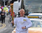 6 June 2012; Torchbearer Brian Brunton, with the Olympic Flame during the London 2012 Olympic Torch Relay through the streets of Dublin. Brian, a member of An Garda Siochána and a keen athlete and has previously carried the torch in the Law Enforcement Torch Run for the Special Olympics in Carolina 1999, Alaska 2001, Japan 2005 and China 2007. Brian was the lead Garda organiser of the Law Enforcement Torch Run for the Special Olympics World Summer Games held in Ireland in 2003. Nominated by An Garda Siochana. Fitzgibbon Street, Dublin. Picture credit: Ray McManus / SPORTSFILE
