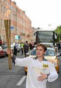 6 June 2012; Torchbearer Robbie Lyons, from The Swan, Co. Laois, has had a rare condition from childhood. He received a kidney transplant in 2009 and joined the Irish Kidney Association’s ‘Transplant Team Ireland’ in 2010. Since then he has represented his country at the World Transplant Games in Gothenburg, Sweden, winning two silver and one gold medal. Nominated by Torch Relay presenting partner Coca-Cola Ireland, with the Olympic Flame during the London 2012 Olympic Torch Relay through the streets of Dublin. Mountjoy Square North, Dublin. Picture credit: Ray McManus / SPORTSFILE