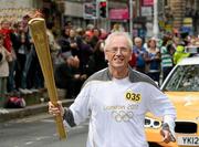 6 June 2012; Torchbearer John Treacy, from Villierstown, Co. Waterford, is a silver medal winner from the 1984 Los Angeles Olympic Games. A legendary figure in Irish athletics, John represented Ireland at four Olympic Games between 1980 and 1992 and twice was the world cross country champion (‘78/’79). He retired from competitive running in 1995 and is currently Chief Executive of the Irish Sports Council, with the Olympic Flame during the London 2012 Olympic Torch Relay through the streets of Dublin. Dame Street, Dublin. Picture credit: Ray McManus / SPORTSFILE