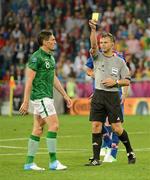 10 June 2012; Keith Andrews, Republic of Ireland, is shown a yellow card by referee Björn Kuipers. EURO2012, Group C, Republic of Ireland v Croatia, Municipal Stadium Poznan, Poznan, Poland. Photo by Sportsfile