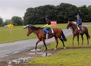 27 June 2012; Akeed Mofeed, left, with stable jockey Alex DeSilva, crosses the road at the curragh with a companion horse, at a Pre-Dubai Duty Free Irish Derby media morning. Curraghbeg Stables, The Curragh, Co. Kildare. Picture credit: David Maher / SPORTSFILE