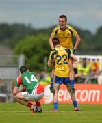 15 July 2012; A dejected Shane Hennelly, left, Mayo, as Roscommon captain Enda Smith is lifted up by team-mate Kieran Kilcline, as they celebrate their victory after the game. Connacht GAA Football Minor Championship Final, Mayo v Roscommon, Dr. Hyde Park, Roscommon. Picture credit: Barry Cregg / SPORTSFILE