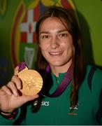 13 August 2012; Olympic champion Katie Taylor celebrates with her gold medal for boxing on their arrival home from the London 2012 Olympic Games. Dublin Airport, Dublin. Picture credit: Ray McManus / SPORTSFILE