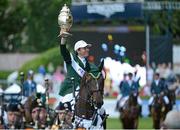 17 August 2012; Clem McMahon, Ireland, on Pacino, celebrates with the Aga Khan trophy following victory in the FEI Nations Cup. FEI Nations Cup. Dublin Horse Show 2012, Main Arena, RDS, Ballsbridge, Dublin. Picture credit: Matt Browne / SPORTSFILE