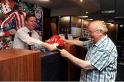 18 August 2012; Gunners fans lose their shirts on bet. Arsenal fans have flocked to Boylesports shops nationwide after the bookmaker announced online that it would offer a free €23 bet in return for disgruntled fans’ Robin van Persie jerseys. Gareth Dunne, Boylesports, hands out a free €23 bet to Arsenal supporter John Ryan, from Swords. Boylesports, Swords, Co. Dublin. Picture credit: Pat Murphy / SPORTSFILE